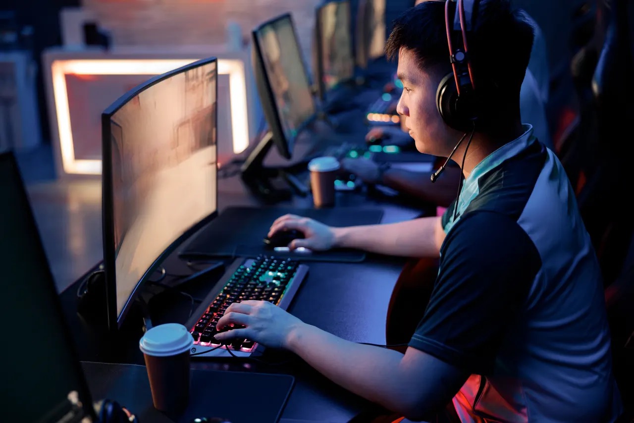 A player at a lit rig in a professional esports setup, mid-match.